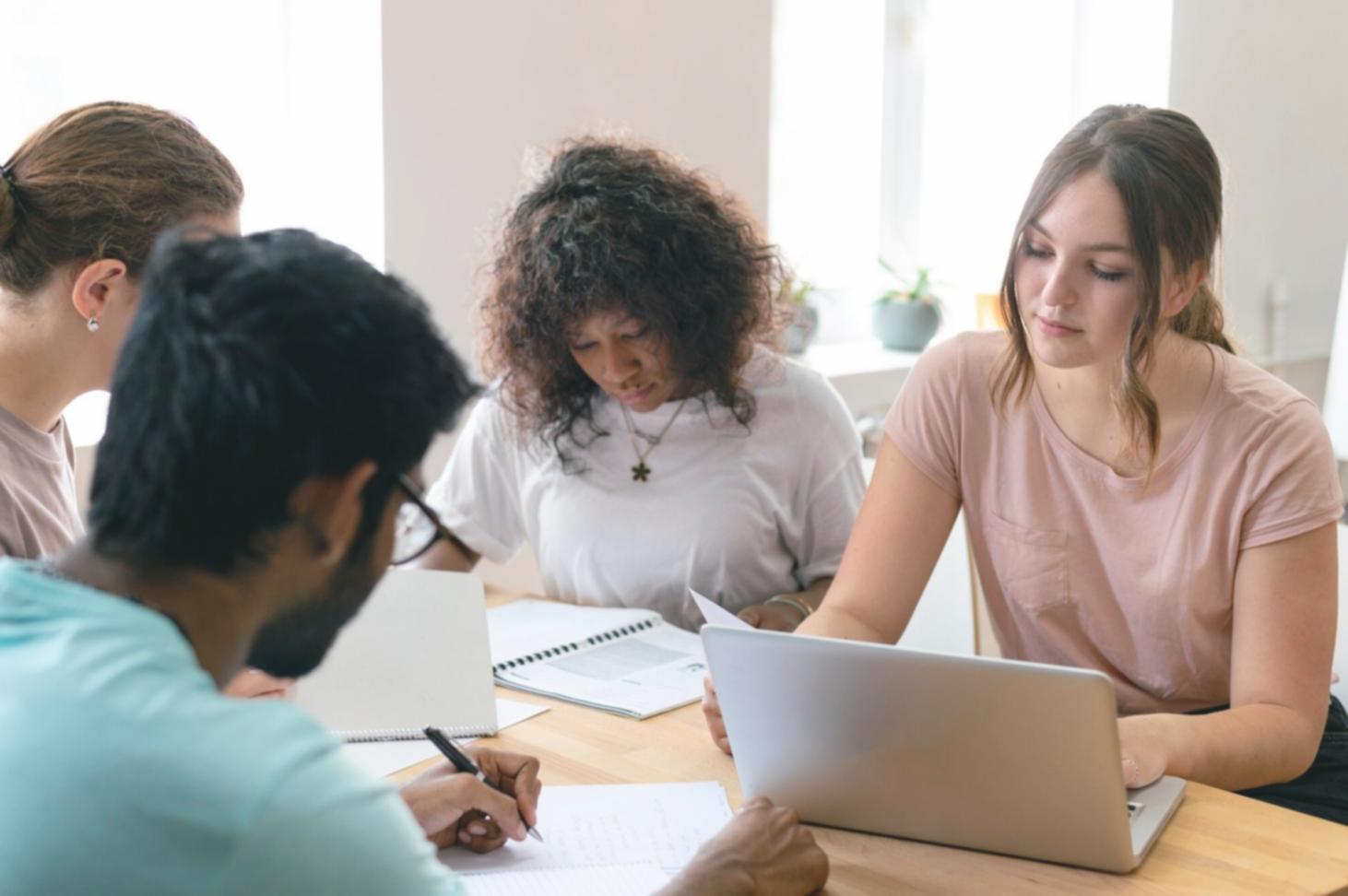 Estudiantes trabajando en análisis financiero con documentos y calculadoras